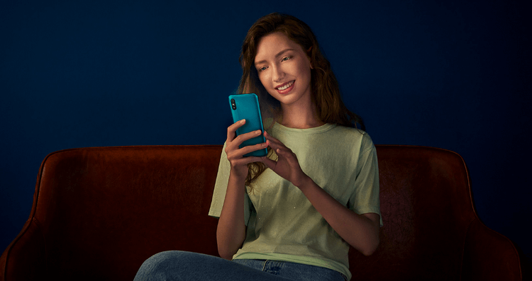 Девушка держит в руках смартфон Redmi 9A